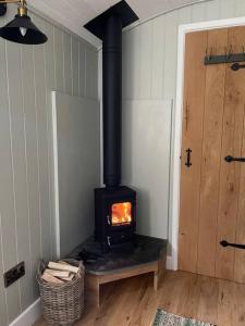 a stove in the corner of a room at Forest View Shepherd Hut in Ewhurst