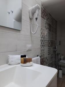 a white bathroom with a phone on the wall at Il Canto Di Iside in Marsala +30 photos