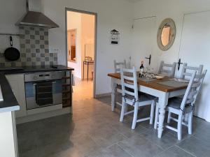 una cucina con tavolo, sedie e piano cottura di Les Jonquilles a Domme