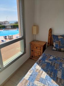 a bedroom with a bed and a window with a view of a pool at Sunny Suite in San Miguel de Abona