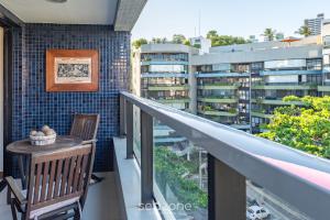 un balcón con mesa y silla y un edificio en Apto luxuoso próximo ao mar OCH0511, en Salvador