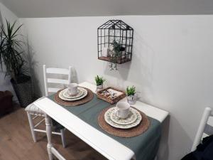 ein weißer Esstisch mit zwei Stühlen und einem Vogelkäfig in der Unterkunft Serenade Cottage in the Country in Hanceville + 9 Fotos