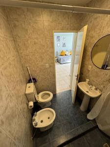 y baño con aseo, lavabo y espejo. en Solar Suites en Neuquén