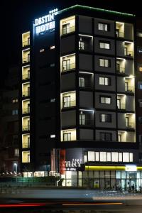 een gebouw met een bord dat 's nachts wijkhotel leest bij Destiny Hotel & SPA in Tirana