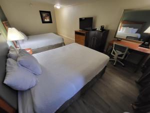 a hotel room with a bed and a desk with a mirror at Ramada by Wyndham Houston Intercontinental Airport East in Humble