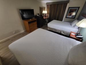 a hotel room with two beds and a flat screen tv at Ramada by Wyndham Houston Intercontinental Airport East in Humble