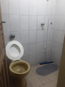 a bathroom with a toilet and a shower stall at Pousada do Toninho in Peruíbe