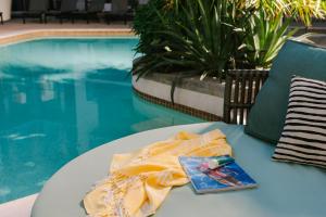 una mesa con un libro al lado de una piscina en Sonder at Mill Ave en Tempe