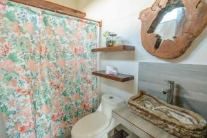 a bathroom with a toilet and a shower curtain at Casa Delfín Tulum in Macario Gomez