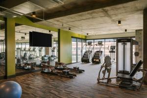 a gym with several tread machines and a flat screen tv at Sonder at Mill Ave in Tempe