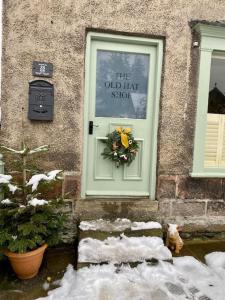 eine Tür eines Hauses mit einem Kranz darauf in der Unterkunft The Old Hat Shop in Cromford