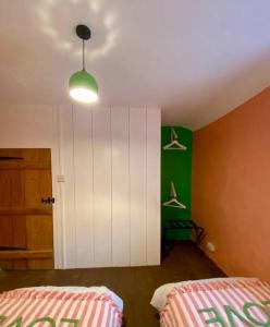 1 dormitorio con 2 camas y pared verde en The Old Hat Shop, en Cromford