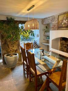 comedor con mesa de cristal y chimenea en The Old Hat Shop, en Cromford