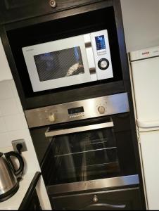 an oven with a microwave above it in a kitchen at Cergy vers Paris 4-6 personnes in Cergy