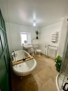 La salle de bains est pourvue d'une baignoire, d'un lavabo et de toilettes. dans l'établissement The Old Hat Shop, à Cromford