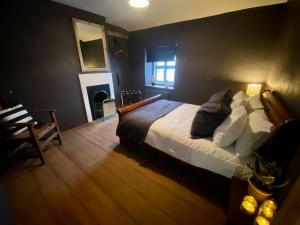 1 dormitorio con 1 cama y chimenea en The Old Hat Shop, en Cromford