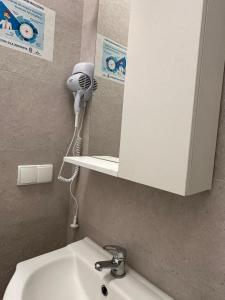 a bathroom with a sink and a mirror and a hair dryer at Rynek 6 in Poznań