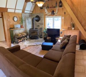 uma sala de estar com um sofá e uma lareira em Chalet unique et chaleureux en pleine nature em Shawinigan