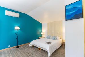 a bedroom with a bed with a blue wall at Auberge Gardoise in Vallérargues