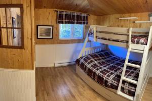 1 Schlafzimmer mit 2 Etagenbetten in einer Hütte in der Unterkunft Chalet unique et chaleureux en pleine nature in Shawinigan