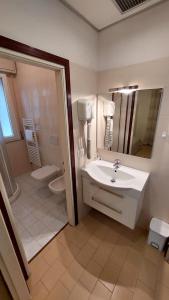 a bathroom with a sink and a toilet and a mirror at Verbena Holiday Apartment in Lazise