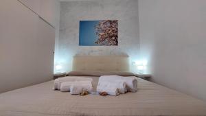 a bedroom with two beds with towels and a painting at Verbena Holiday Apartment in Lazise