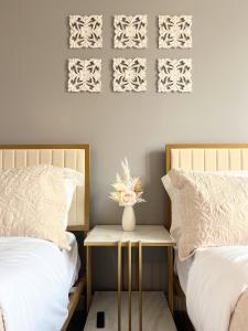 泰森斯角的住宿－Premier Escape Tysons 4 Beds，一间卧室配有两张床和一张带花瓶的桌子。