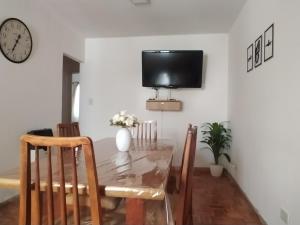 een eetkamer met een tafel en een tv aan de muur bij La Victoria in Rosario