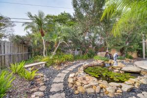 a garden with a pond with lilies and a fountain at Centrally Located Merritt Island Home Pool, Porch in Merritt Island
