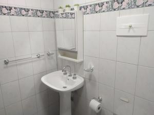 a white bathroom with a sink and a mirror at La Victoria in Rosario