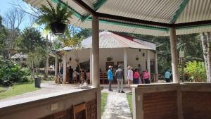 Un grupo de personas paradas afuera de un edificio en Centro ecoturistico Arco del Tiempo, en Cintalapa de Figueroa