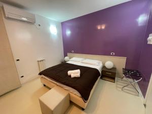 a bedroom with a large bed with a purple wall at B&B Elia's in Cagliari