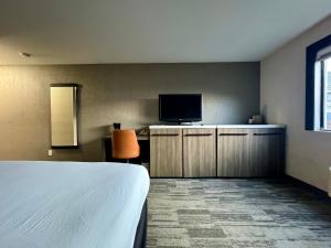 a hotel room with a bed and a flat screen tv at Modesto Hotel - Suite A in Modesto