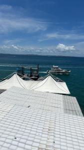 uma doca com um telhado branco e a água em Sol vitória Marina em Lauro de Freitas
