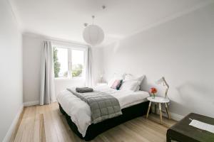 Un dormitorio blanco con una cama grande y una ventana en The Pear Orchard Lodge, en Richmond