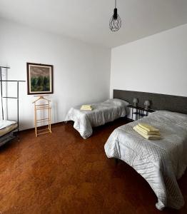 Habitación con 2 camas y una pintura en la pared. en R & B Emilia 54, en Cadeo
