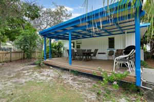 a house with a blue roof and a wooden deck at The Shack Rainbow Beach - Pets Welcome - Fully Fenced - Close to Beach in Rainbow Beach