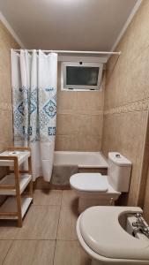 a bathroom with a toilet and a tub and a sink at Sunny Suite in San Miguel de Abona