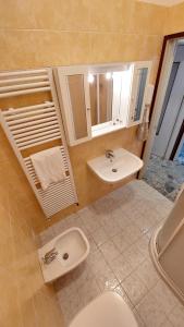 La salle de bains est pourvue d'un lavabo, de toilettes et d'un miroir. dans l'établissement Magnolia Holiday Apartment, à Lazise