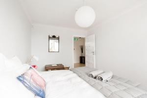 Un dormitorio blanco con una cama con toallas. en The Pear Orchard Lodge, en Richmond