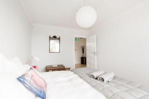 a white bedroom with a bed with towels on it at The Pear Orchard Lodge in Richmond