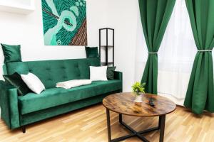 sala de estar con sofá verde y mesa en City Apartment Top Location, quiet and cozy Ideal to relax or work, en Viena