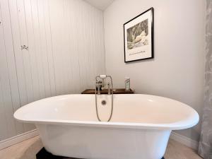 a bath tub in a bathroom with a picture on the wall at Roberts Roost Resort in Quesnel