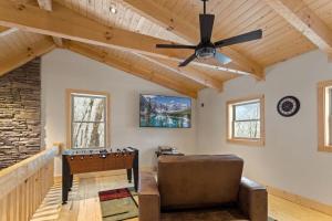 a living room with a ceiling fan and a couch at Cozy Rustic Cabin in Sugar Mountain