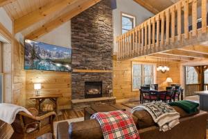 a living room with a fireplace and a staircase at Cozy Rustic Cabin in Sugar Mountain