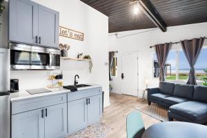 a kitchen and living room with white cabinets and a couch at South Bay Inn in Westport