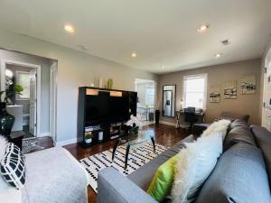 un soggiorno con divano e TV a schermo piatto di Modern & Spacious-walk to metro w/ parking On-site a Silver Spring