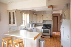 a kitchen with white cabinets and a kitchen island with stools at Private 313 Acre retreat/lakes/direct forest entry in Buena Vista