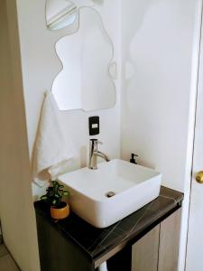 a bathroom with a white sink on a counter at Magnífica habitación rodeada de arte en Centro Histórico in Mexico City
