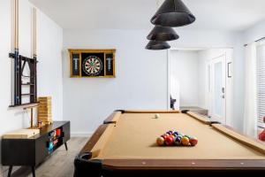 a room with a pool table and a clock at Timeless-Texas-Inn - Heated Pool Oasis & Lux Vibe in Round Rock